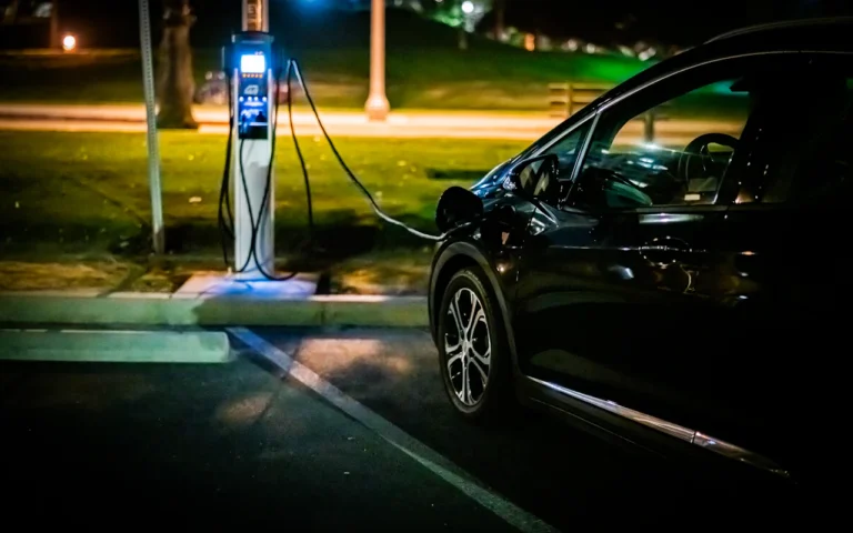 Carro elétrico carregando à noite em um ponto de recarga