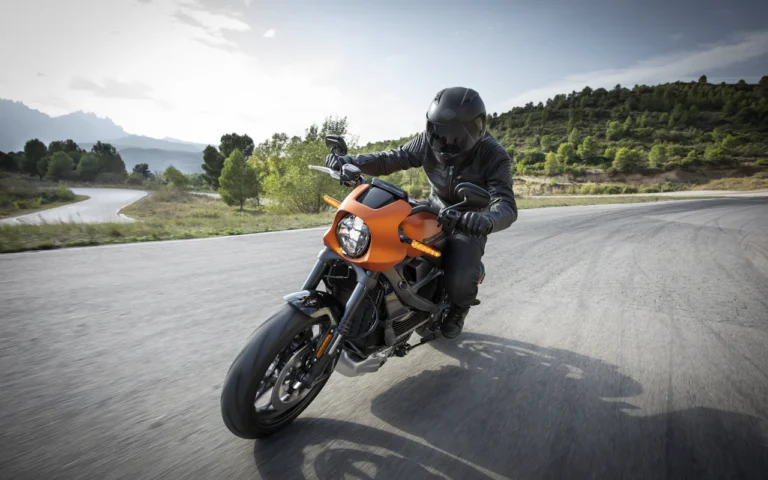 Motociclista pilotando uma moto elétrica em uma estrada