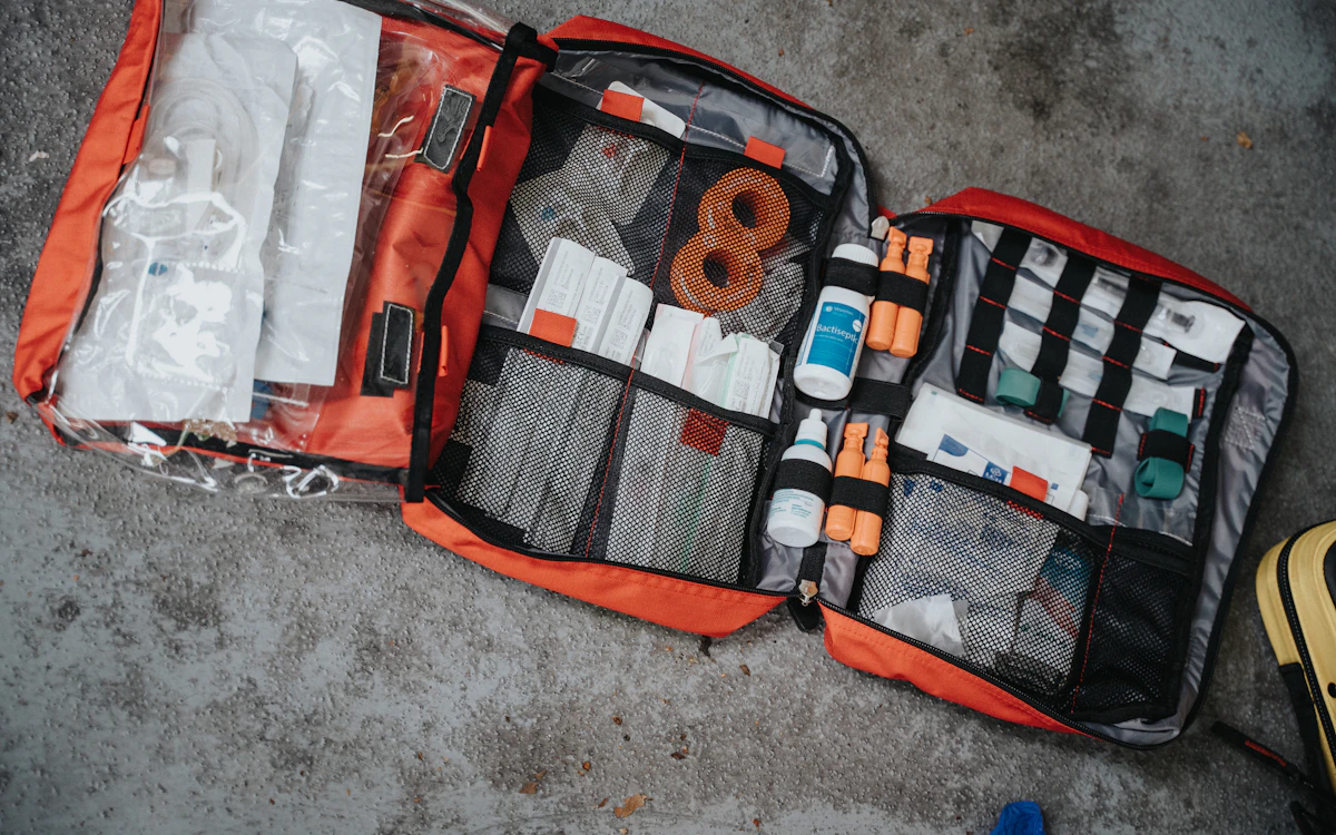 Kit de primeiros socorros aberto, com ataduras e materiais de atendimento